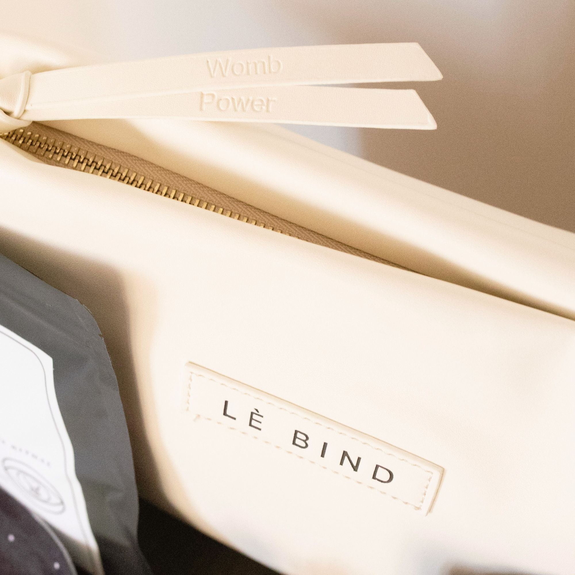 Close-up detail of the Bellibind luxury mom essentials and push present purse featuring the embroidered phrase 'Womb Power.'