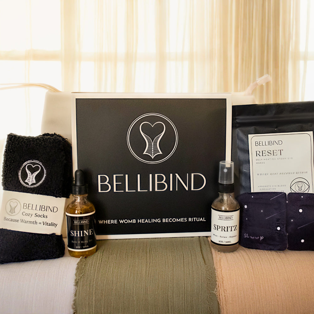 A postpartum mother rests one hand on her bare belly while holding Bellibind Shine Belli and Body Oil in the other.